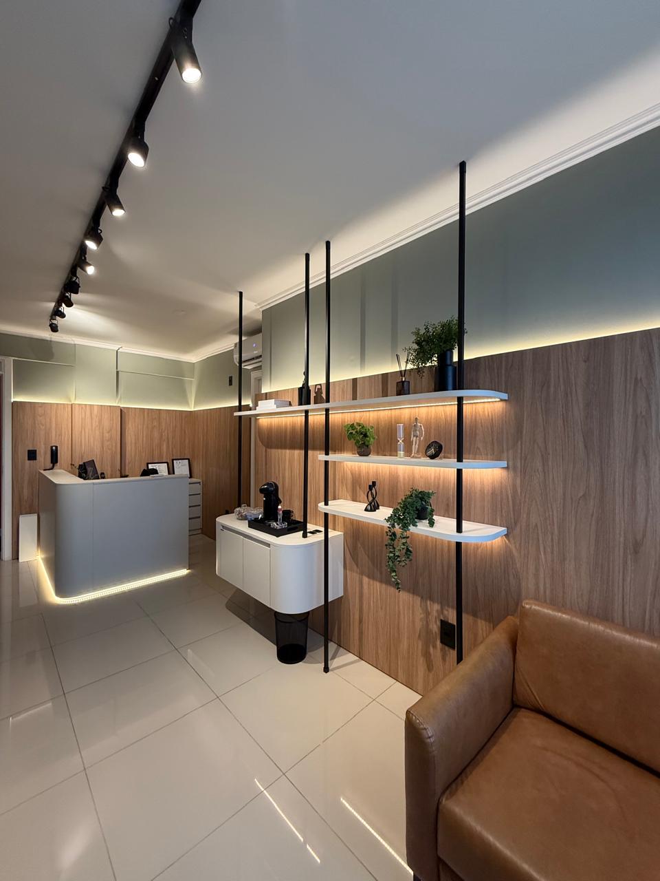 Sala de espera do consultório — estante com iluminação e decoração